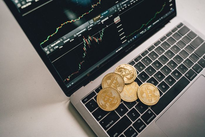 Una computadora portátil con un montón de monedas de oro en el teclado.